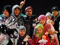 Migrants smile after disembarking from the Sierra Leone-flagged vessel Ezadeen at Corigliano Calabro harbour (Reuters)