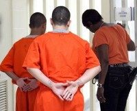 Two youths at the Texas Youth Commission facility in Marlin, Texas, are accompanied by a guard as they walk down the hall.