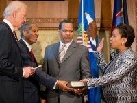 Vice President Joe Biden, accompanied by Loretta Lynch's father Lorenzo Lynch, second from left, and Loretta Lynch's husband Stephen Hargrove, second from right, administers the oath of office to Loretta Lynch as the 83rd Attorney General of the U.S., Monday, April 27, 2015, during a ceremony at the Justice Department in Washington.