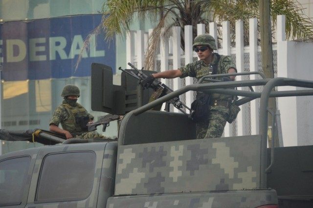 Mexican soldiers guard the Federal Police building in Matamoros following a grenade attack by cartel members.