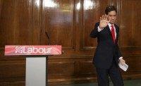 Opposition Labour Party leader Ed Miliband waves after announcing his resignation as leader at a news conference in London