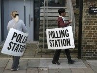 Polling station workers place signs outside a polling station in Islington, in readiness for voting in Britain's general election, in London (REUTERS/Peter Nicholls)