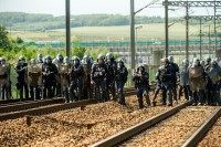 French riot police officers take position to drive out protesting French employees (unseen) of the company English Channel passenger and freight ferry company "MyFerryLink", who block the railway tracks of the Eurostar Channel tunnel line, on June 23, 2015 in Calais, northern France. Eurotunnel said that train services had been suspended in both directions on June 23 after protesting French sailors got onto the tracks of the line that links France and Britain and torched tyres. AFP PHOTO / PHILIPPE HUGUEN