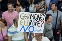 'NO' protester supporter holds a banner as they gather in front of the parliament building in Athens on July 3, 2015.
