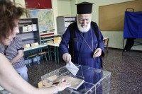 ATHENS, GREECE - JULY 5: An Orthodox priest puts a referendum vote in the ballot box at a school on July 5, 2015 in Athens, Greece. The people of Greece are going to the polls to decide if the country should accept the terms and conditions of a bailout with its creditors. Greek Prime Minister Alexis Tsipras is urging people to vote 'a proud no' to European creditors' proposals, and 'live with dignity in Europe'. 'Yes' campaigners believe that a no vote would mean financial ruin for Greece and the loss of the Euro currency. (Photo by Milos Bicanski/Getty Images)