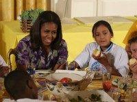 First lady Michelle Obama sits down with local students to eat vegetables that were recently harvested from the White House garden, in the East Room at the White House June 3, 2015 in Washington, DC. The first lady and local students enjoyed eating the vegetables they planted in the garden on the South Lawn to initiate a national conversation around the health and well-being. (Photo by