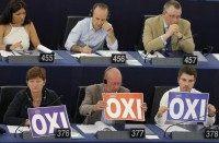 Members of the European Parliament hold posters with the word "No" (Oxi in Greek) during a debate at the European Parliament in Strasbourg