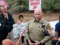 Pinal County Head Sheriff Paul Babeu speaks with anti-immigration activists and the media during a protest along Mt. Lemmon Road in anticipation of buses carrying illegal immigrants on Jully 15, 2014 in Oracle, Arizona. About 300 protesters lined the road waiting for a busload of illegal immigrants who are to be housed at a facility in Oracle.