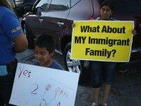 Kevin Valazquez,6, (L) and Irma Lopez Aguilar stand with others as they show their support for the Obama administration's immigration reform plan on July 9, 2015 in Homestead, Florida. The organizers held the protest the night before the 5th Circuit Court of Appeals in New Orleans is expected to consider lifting the injunction on the Obama administrations executive action to allow parents of U.S. citizens and legal permanent residents to gain temporary status in the U.S., as well as to expand the deferred action program for undocumented youth. (Photo by