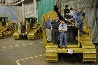 Oil inches lower on Caterpillar, weak jobs report