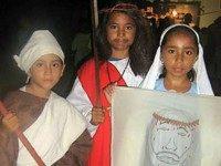 three Belizean children from San Pedro Town dressed as Christian saints, martyrs and Biblical figures for the observance of Allhallowtide. It is common for Christian schools to host parties on the first two days of this triduum, All Hallows' Eve (Halloween) and All Hallows' Day (All Saints' Day), in which costumes of this kind are worn. In some Christian denominations, children also dress up as the Reformers for Reformation Day events, which are often celebrated alongside those of All Hallows' Eve.