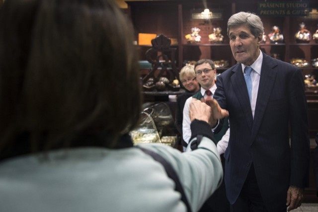 United States Secretary of State John Kerry shakes hands with a woman at  chocolate store Fassbender and Rausch during an unscheduled stop in Berlin,