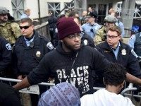 A member of the Black Lives Matter movement tries to keep demonstrators back from the police line in front of a police precinct during a protest in Minneapolis on November 18.