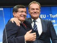 Turkish Prime Minister Ahmet Davutoglu (L) hugs European Council president Donald Tusk during a press conference at the end of a summit on relations between the European Union and Turkey and on the migration crisis at the European Council in Brussels on November 29, 2015. AFP PHOTO / EMMANUEL DUNAND / AFP / EMMANUEL DUNAND (Photo credit should read