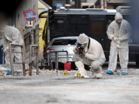 Police forensic experts search for evidence outside the Greece's industry association offices in Athens, after a bomb exploded on early November 24, 2015.