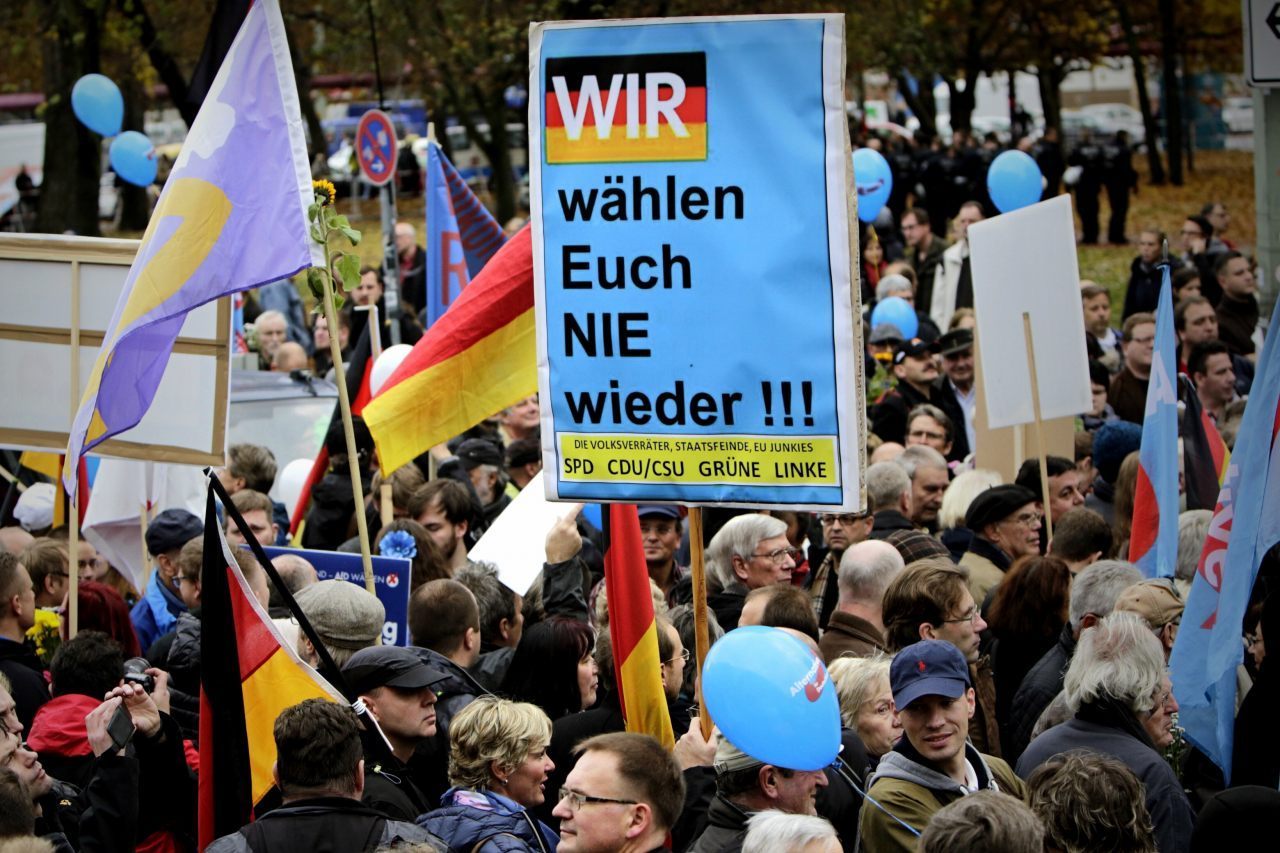 A protester holds a sign saying "We'll never vote for you again!!!" (Carsten Koall/Getty Images)