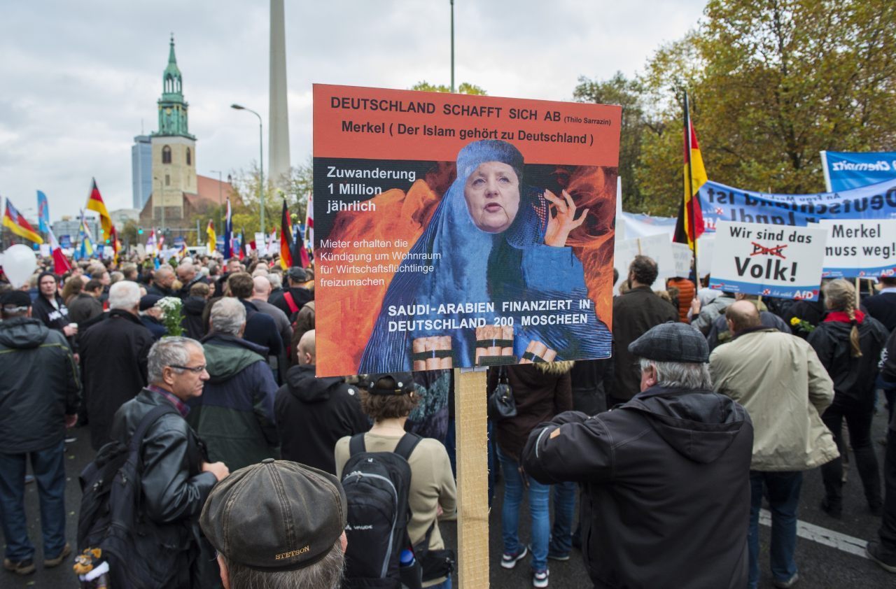 A protester holds a placard claiming Saudi Arabia finances 200 mosques in Germany (Carsten Koall/Getty Images)