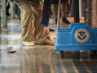 A passenger removes their shoes before passing through the passenger security checkpoint at John F. Kennedy International Airport's Terminal 8 on October 22, 2010.