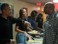 Malia Obama (2nd L), daughter of US President Barack Obama (L), smiles as they serve Thanksgiving dinner to homeless military veterans with First Lady Michelle Obama (3rd L) and daughter Sasha at Friendship Place in Washington, DC, on November 25, 2015. President Barack Obama sought to reassure jittery Americans traveling home for Thanksgiving that they face no credible and immediate terror threat and said that security services are working around the clock to keep the US safe. AFP PHOTO/ NICHOLAS KAMM / AFP / NICHOLAS KAMM (Photo credit should read