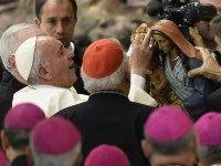 Pope Francis (L) adjusts crowns on a statue of the Virgin Mary during an audience to the participants in the pilgrimage of Gypsies, on October 26, 2015 at Paul VI audience hall at the Vatican. AFP PHOTO / ANDREAS SOLARO (Photo credit should read