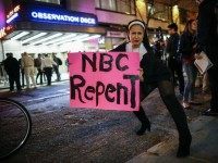 A woman dressed as nun holds a poster as she poses for a photo during a protest in front of NBC studios. (Kena Betancur/AFP/Getty Images)