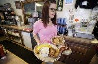 FILE - In this June 19, 2015 file photo, waitress Laura Haege carries a breakfast to be serve at the Waveland Cafe, in Des Moines, Iowa. Payroll processor ADP reports how many jobs private employers added in October on Wednesday, Nov. 4, 2015. (AP Photo/Charlie Neibergall, File)