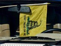 A Gadsden flag hangs from a rearview mirror of a car in the parking lot during the Delaware State Sportsmen's Association Second Amendment rally at the Modern Maturity Center on January 20, 2013 in Dover, Delaware. U.S. President Barack Obama recently unveiled a package of gun control proposals that include universal background checks and bans on assault weapons and high-capacity magazines. (Photo by