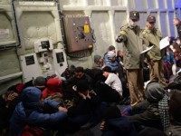 Syrian migrants wait aboard the Turkish Coast Guard ship Umut after being rescued while attempting to reach the Greek Island Chios on the Agean Sea near Izmir in the night of December 9 to December 10, 2015. More than 886,000 migrants have arrived in Europe by sea so far this year, according to the latest UN figures. / AFP / BULENT KILIC (Photo credit should read