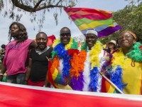 People hold rainbow flags as they take part in the Gay Pride parade in Entebbe on August 8, 2015. Ugandan activists gathered for a gay pride rally, celebrating one year since the overturning of a strict anti-homosexuality law but fearing more tough legislation may be on its way. Homosexuality remains illegal in Uganda, punishable by a jail sentence. AFP PHOTO/ ISAAC KASAMANI (Photo credit should read