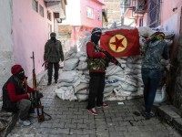 A flag of Kurdish workers Party ( PKK ) hangs on a barricade as armed kurdish militants man a barricade, on November 18, 2015 in the Sur district of Diyarbakir. Tensions rose when pro-Kurdish MP Leyla Zana began her oath with "Biji Asiti", or "Long live peace" in Kurdish. The phrase triggered a storm that recalled her memorable swearing-in 24 years ago when she also spoke the language that was then still taboo in public. AFP PHOTO/ILYAS AKENGIN