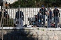 Israeli police officers investigate on the body of one of the reported Palestinian assailants killed during an attack at Damascus Gate, a main entrance to Jerusalem's Old City on February 3, 2016.
