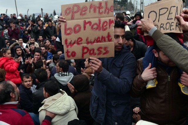 Syrian and Iraqi refugees trapped at the Greek-Macedonian border protest demanding the opening of the borders on February 28, 2016.  More than 5,000 people were trapped at the Idomeni camp after four Balkan countries announced a daily cap on migrant arrivals. Slovenia and Croatia, both EU members, and Serbia and Macedonia said they would restrict the number of daily arrivals to 580 per day. / AFP / LOUISA GOULIAMAKI        (Photo credit should read LOUISA GOULIAMAKI/AFP/Getty Images)