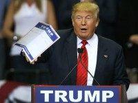 Republican presidential candidate Donald Trump tosses a paper into the crowd as he speaks during a campaign rally at the University of South Florida Sun Dome on February 12, 2016 in Tampa, Florida.