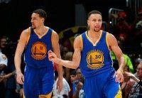 Stephen Curry (R) of the Golden State Warriors reacts after a basket against the Atlanta Hawks, at Philips Arena in Atlanta, Georgia, on February 22, 2016