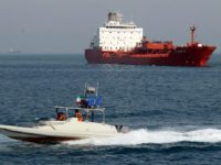 An Iranian Revolutionary Guard speedboat cruises past an oil tanker off the port of Bandar Abbas, Iran, on July 2, 2012, in recent years, Iranian oil exports have fallen from more than 2.2 million barrels per day to about one million