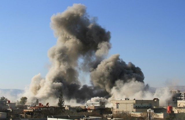 Smoke ascends after a Syrian military helicopter allegedly drops a barrel bomb over Daraya on February 5, 2014
