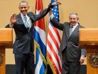 Cuban President Raul Castro lifts up the arm of President Barack Obama at the conclusion of their joint news conference at the Palace of the Revolution, Monday, March 21, 2016, in Havana, Cuba.
