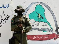 IRAQ, Basra : An Iraqi fighter of the Shiite group Asaib Ahl al-Haq (The League of the Righteous) stands guard outside the militia's headquarters on May 18, 2015 in the Iraqi mainly Shiite southern city of Basra, as Shiite militias converged on Ramadi in a bid to recapture it from jihadists who dealt the Iraqi government a stinging blow by overrunning the city in a deadly three-day blitz. "When it comes to readiness, we have more than 3,000 fighters waiting for a signal from the secretary general (of Asaib) Sheikh Qais al-Khazali," spokesman Jawad al-Talabawi said. AFP PHOTO / HAIDAR MOHAMMED ALI