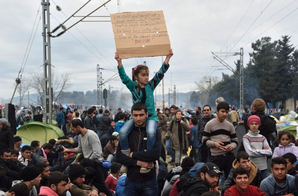 Migrants and refugees take part in a protest asking for the opening of the border on March 12, 2016, in a makeshift camp at the Greek-Macedonian border, near the Greek village of Idomeni, where thousands of refugees and migrants are stranded by the Balkan border blockade. Greece aims to deal swiftly with the migrant overflow at the Idomeni refugee camp on the Greek-Macedonian border where some 12,000 people are camping in miserable conditions waiting to cross. / AFP / DANIEL MIHAILESCU (Photo credit should read DANIEL MIHAILESCU/AFP/Getty Images)
