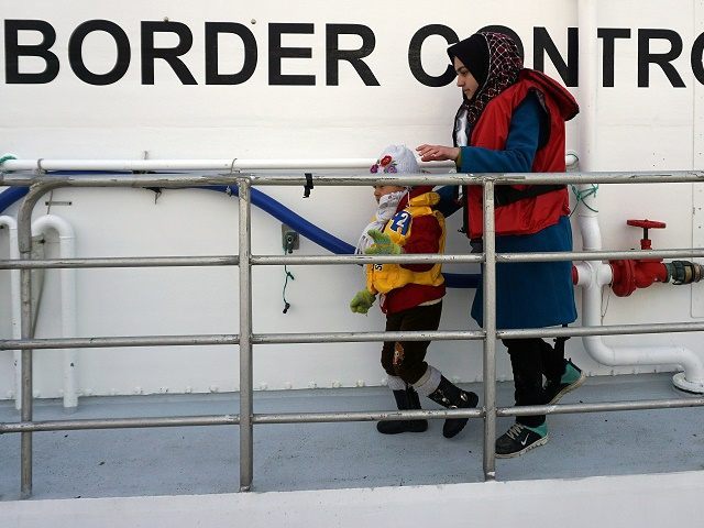 A woman and her child disembarks from a Norwegian Frontex  vessel at the port of Mytilene in the island of Lesbos , on March 16, 2016. The Nowergian vessel  saved some 250 refugees and migrants who attempted  the perilious crossing from Turkey to the Greek island on Lesbos   European leaders scrambled Wednesday to salvage an under-fire deal with Turkey to ease the migrant crisis with a round of shuttle diplomacy on the eve of a crunch summit. / AFP / STR        (Photo credit should read STR/AFP/Getty Images)