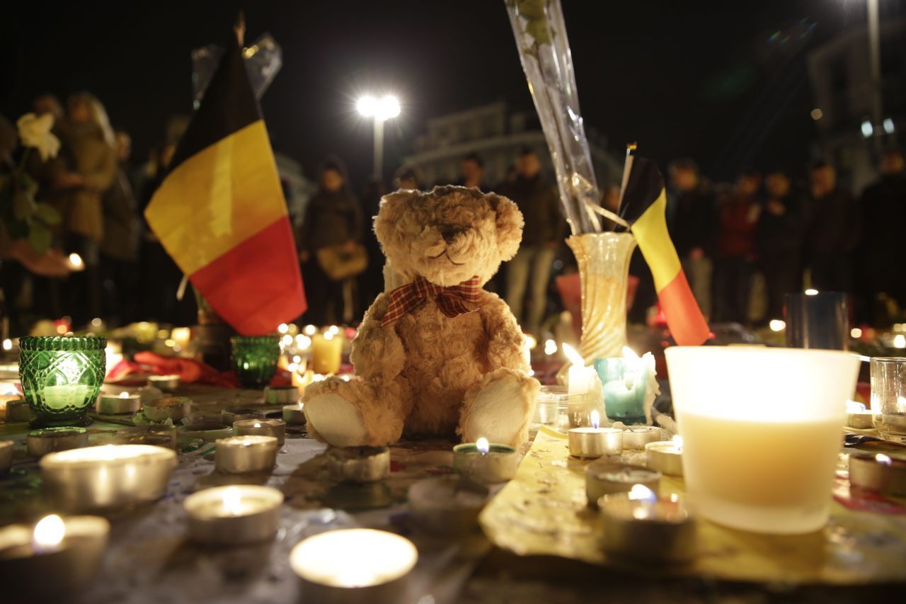 A Belgian flag, candles and a Teddy bear are pictured as people gather at a makeshift memorial on the Place de la Bourse (Beursplein) in Brussels on March 23, 2016, a day after a triple bomb attack, which responsibility was claimed by the Islamic State group, left 31 dead and hundreds injured in the Belgian capital. World leaders united in condemning the carnage in Brussels and vowed to combat terrorism, after Islamic State bombers killed 31 people in a strike at the symbolic heart of the EU. AFP PHOTO / KENZO TRIBOUILLARD / AFP / KENZO TRIBOUILLARD (Photo credit should read KENZO TRIBOUILLARD/AFP/Getty Images)