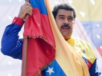 Venezuelan President Nicolas Maduro holds a flag during a demonstration against the United States' decision to renew sanctions on several top Venezuelan officials, in Caracas on March 12, 2016