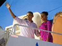 President Barack Obama, left, and first lady Michelle Obama wave as they board Air Force One to depart from Joint Base Pearl Harbor-Hickam at the end of their family vacation, on Saturday, Jan. 2, 2016, in Honolulu, Hawaii. (AP Photo/Evan Vucci)