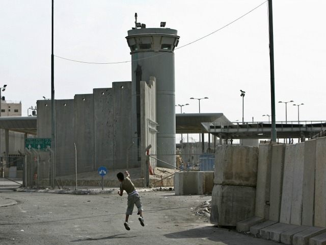 A Palestinian boy throws stones towards an Israeli army watchtower during clashes between Palestinian stone-throwers and Israeli soldiers at the Qalandia checkpoint near the West Bank city of Ramallah on October 16, 2009. Israel slammed the adoption of an 'unjust' UN report on the Gaza war on October 16, warning that it damages Middle East peace efforts and encourages 'terrorist organisations' around the world.