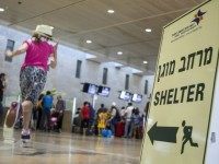 A girl runs past a sign directing passengers to a shelter at Ben Gurion International airport, near the Mediterranean Israeli coastal city of Tel Aviv on August 21, 2014, following a warning issued by Hamas's armed wing that they will target the airport from 6 am (0300 GMT) in a bid to disrupt air traffic.