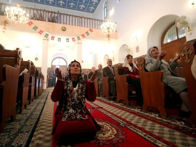 An Iraqi Christian woman prays at the Chaldean church in the southern city of Basra on January 1, 2016.