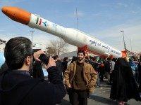 Iranians take pictures of the Simorgh (Phoenix) satellite rocket during celebrations in Tehran to mark the 37th anniversary of the Islamic revolution on February 11, 2016.