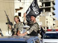 Militant Islamic State fighters wave flags as they take part in a military parade along the streets of Syria’s northern Raqqa province June 30, 2014. REUTERS/Stringer