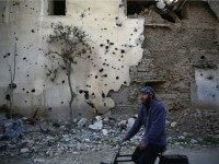 Syria, Jobar : CORRECTION / A Syrian man rides a bike in the neighbourhood of Jobar, on the eastern outskirts of the capital Damascus, on January 23, 2016.