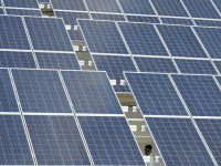 A member of the Presidential Security Group (PSG) walks under the solar panels at the roof deck of a mall in Manila on November 24, 2014. The 5,760 solar panels have been installed on the roof deck of the multi-level carpark of SM City mall.
